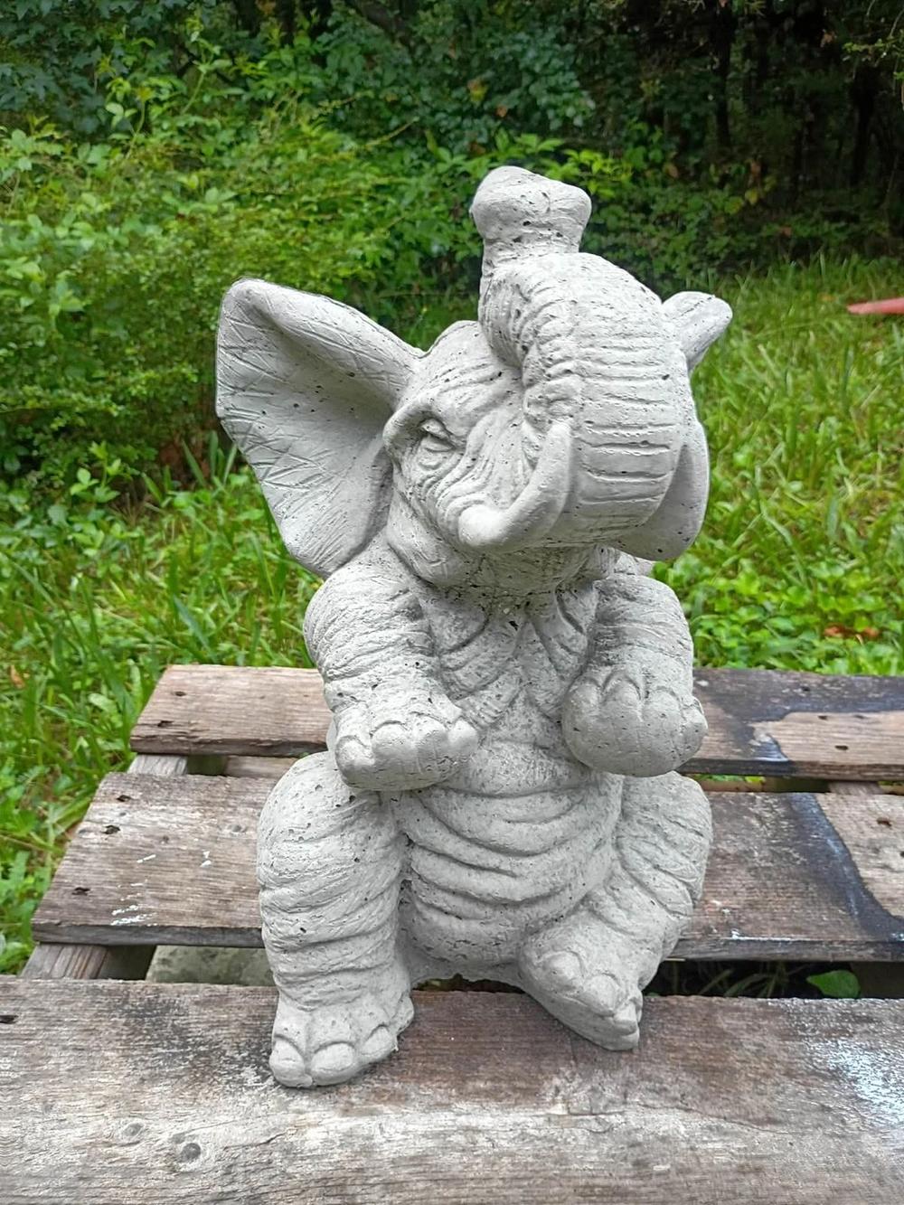 Cute concrete baby elephant statue with trunk raised in Villa Rica, GA