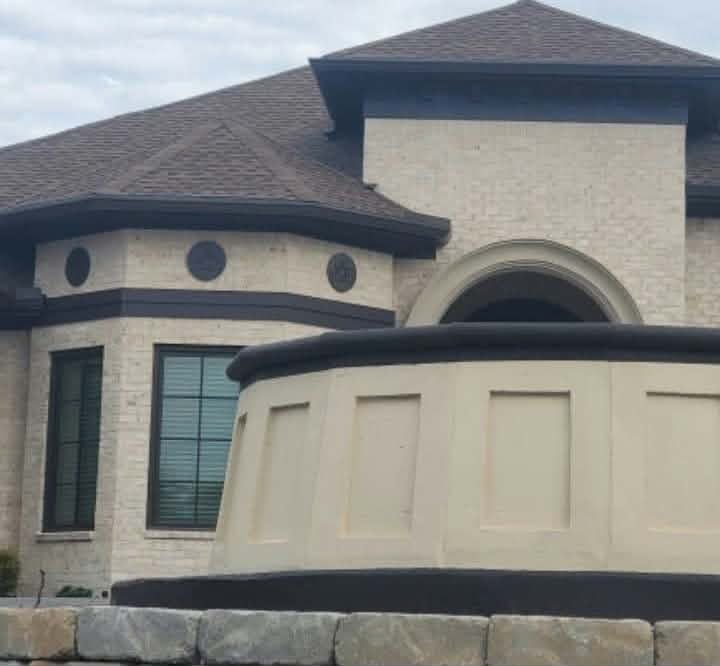 Close-up of the cream finished fountain panels with a dark cap in front of the home