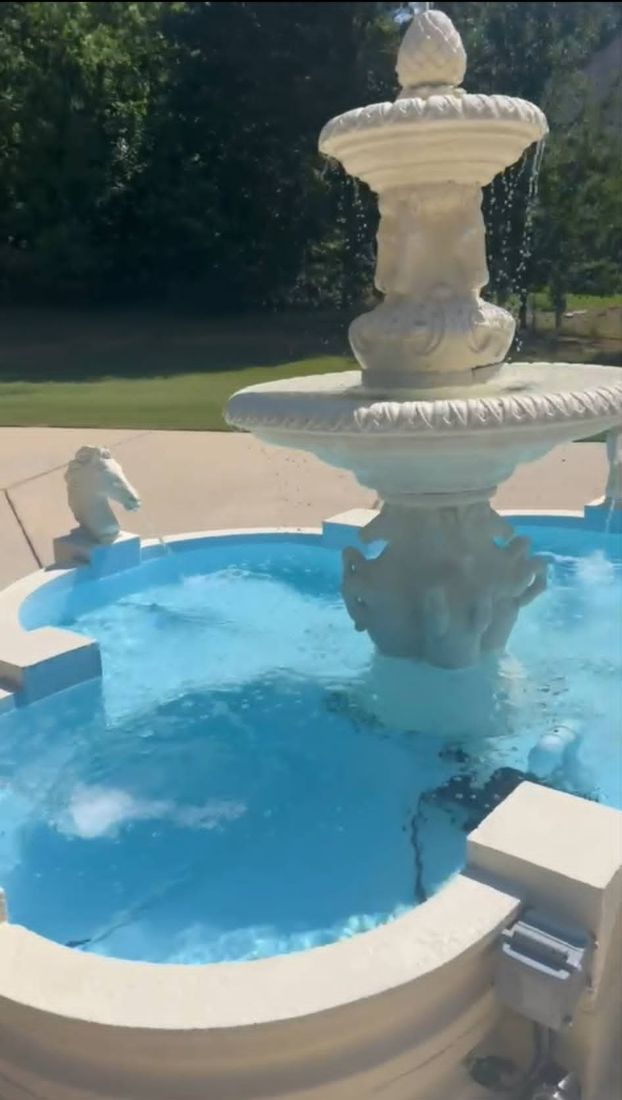 Completed Clover fountain with pineapple finial and horse head spouts, running on a sunny day