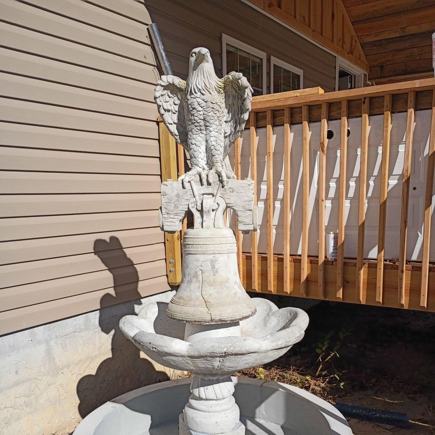 Sculptural fountain with a perched eagle over a Liberty Bell in a clamshell basin