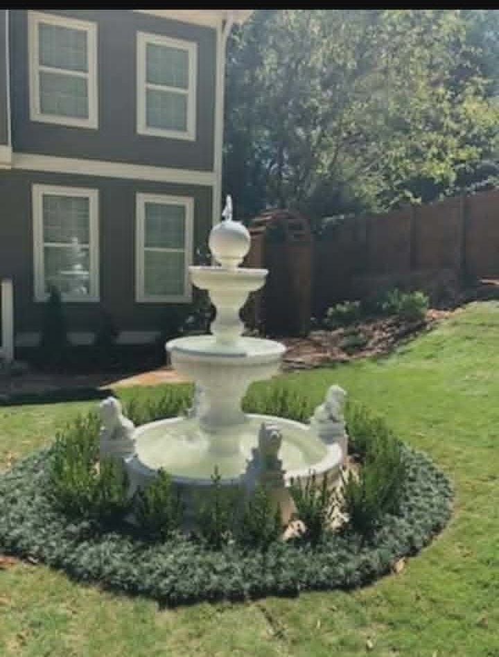 Majestic fountain with lion surround set in a circular hedge bed