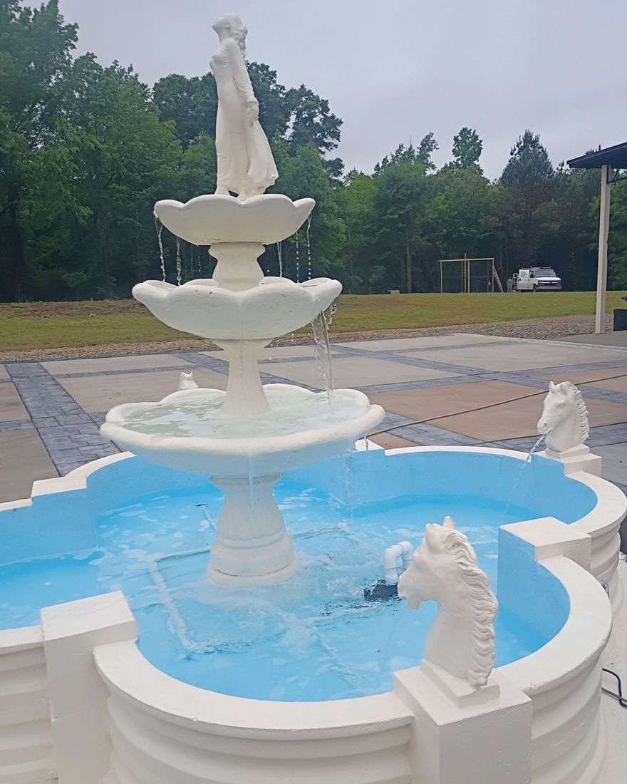 Three-tier lady fountain with horse head spouts in a scalloped Clover pool surround