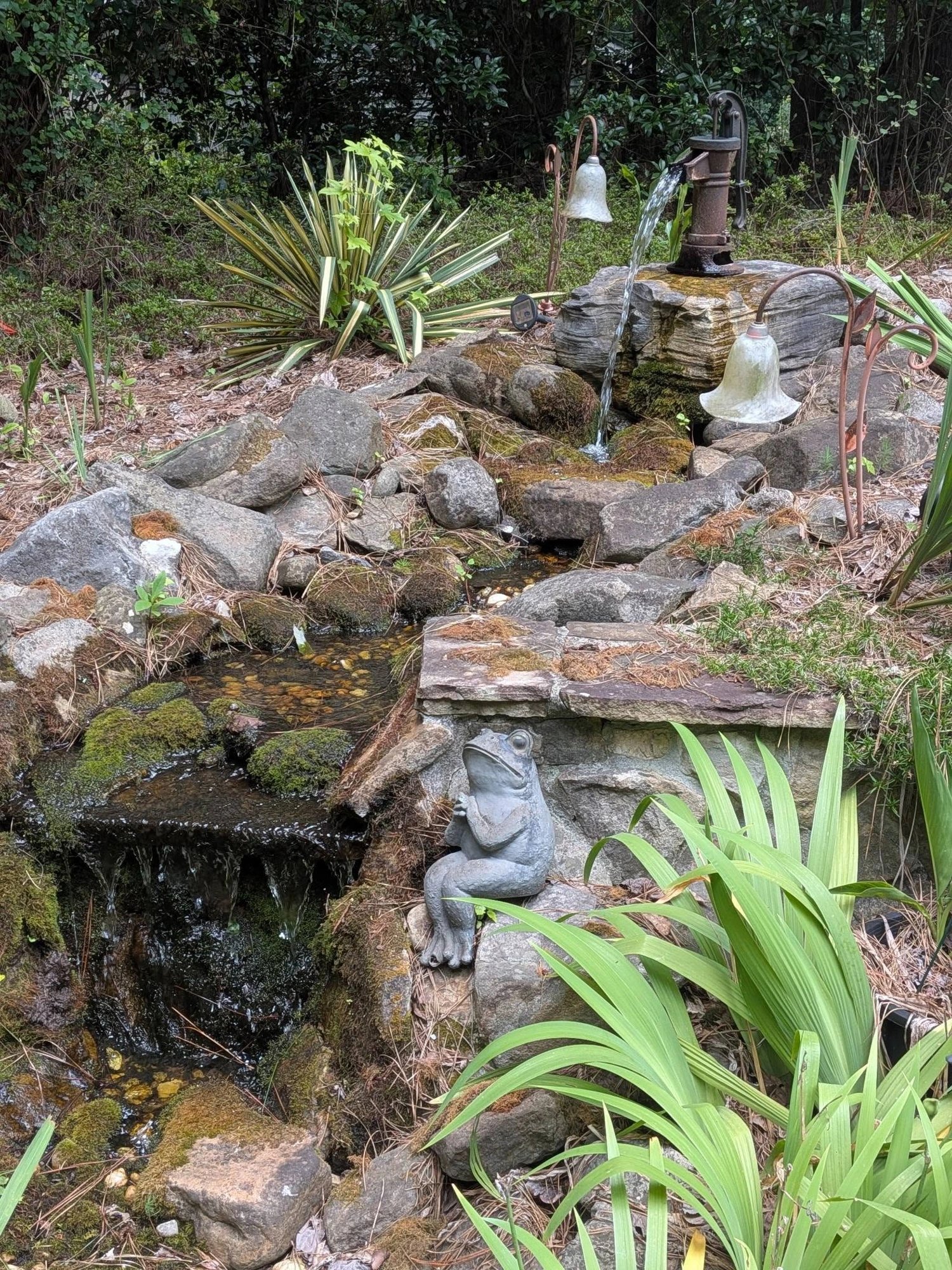 The restored pond waterfall running clear again with a frog statue