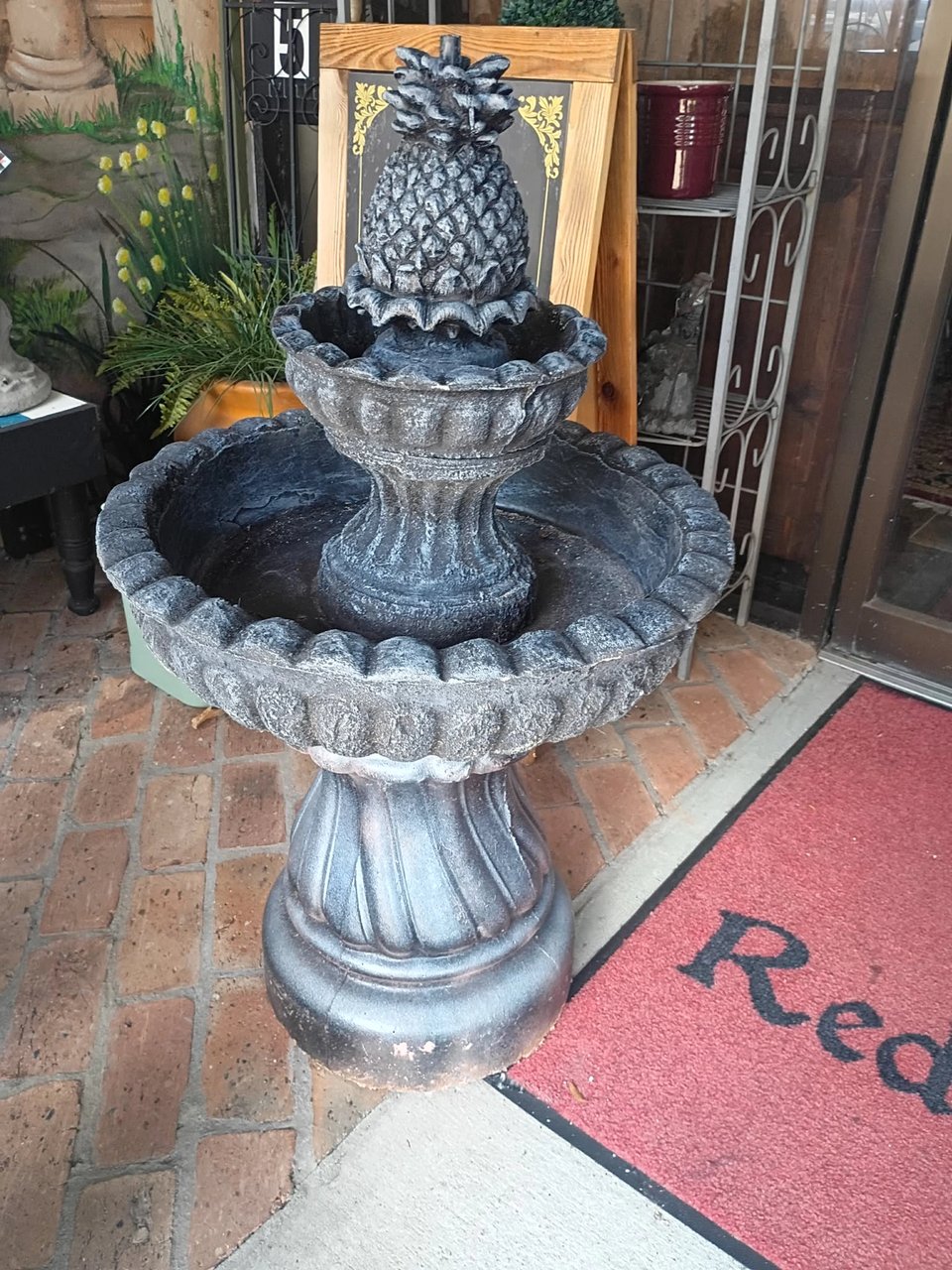 Two-tier charcoal pineapple fountain on display at Red Door Antiques in LaGrange, GA