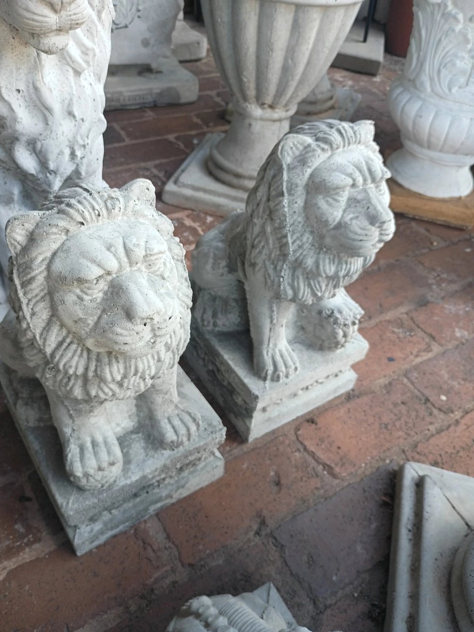 Pair of concrete sitting lion statues on display at Red Door Antiques in LaGrange, GA