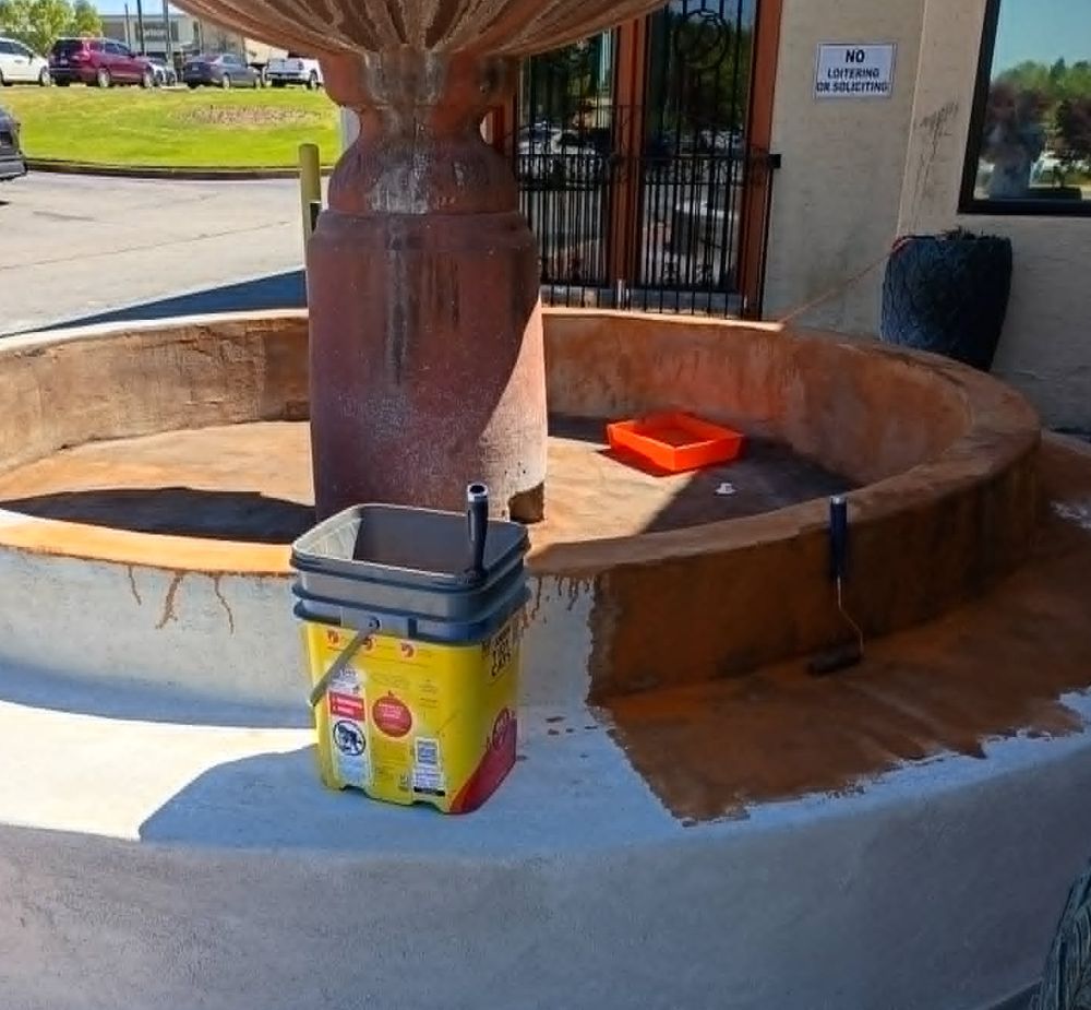 New terracotta stain being applied to the restored fountain basin